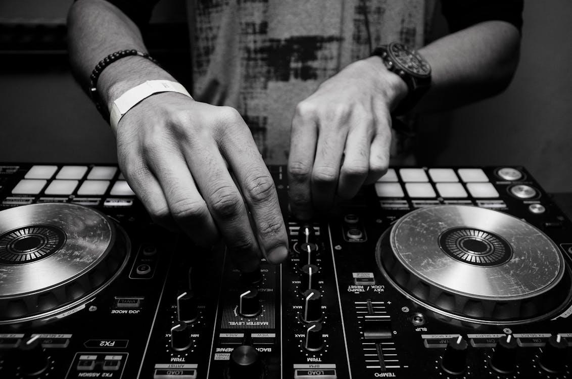 A DJ adjusting the audio levels on a controller for an event