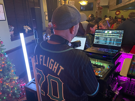 A photo showing a DJ working on his equipment